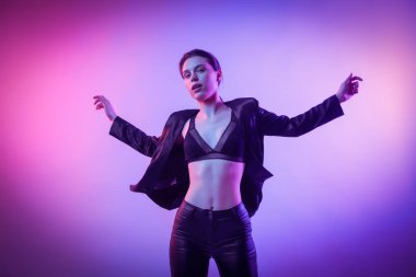 Savaşçı kadını pembe mavi neon ışık, Trendy moda saç modeli. Yüksek moda. Kadın ceket, pantolon ve iç çamaşırı neon ışıkları sinema gece portresi