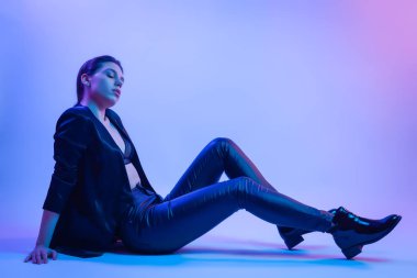İçinde neon kadın sinema gece portresi. Şık elbiseleri renkli parlak neon ışıkları Studio, tişört ve pantolon güzel kadın portresi poz içinde yüksek moda model kız. 