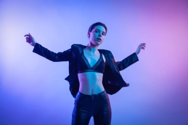 Savaşçı kadını pembe mavi neon ışık, Trendy moda saç modeli. Yüksek moda. Kadın ceket, pantolon ve iç çamaşırı neon ışıkları sinema gece portresi