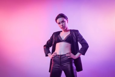 İçinde neon kadın sinema gece portresi. Şık elbiseleri renkli parlak neon ışıkları Studio, tişört ve pantolon güzel kadın portresi poz içinde yüksek moda model kız. 