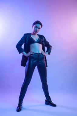 İçinde neon kadın sinema gece portresi. Şık elbiseleri renkli parlak neon ışıkları Studio, tişört ve pantolon güzel kadın portresi poz içinde yüksek moda model kız. 