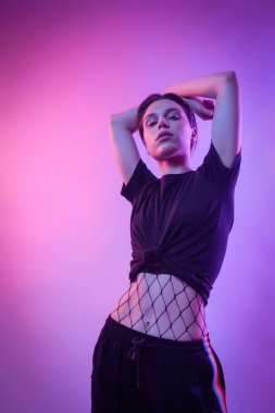 İçinde neon kadın sinema gece portresi. Renkli ışıklar sandalyede poz bir şık giysiler içinde güzel ve genç birbayan. Sanat Güzellik Portresi. Vücut parlayan gökkuşağı ile ıslak kız