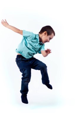 Mavi Jeans, koyu saçlı küçük boy gülümseyerek mavi t-shirt atlama ve izole beyaz arka planda bir fotoğraf Studio eğlenmek polo