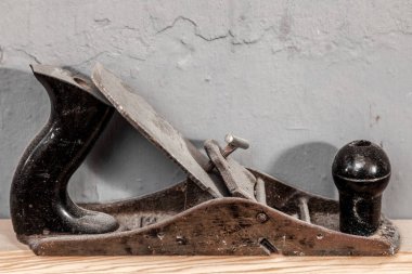 Yakın çekim siyah metal planya ve plastik arka planı gri bir duvar ahşap bir masa üzerinde duruyor ağaç işleme için