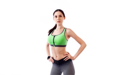 Genç ince kadın sporcu bir sportif yeşil kısa top ve poz spor salonu tozluk ve güleryüzlü bir beyaz izole arka planda Studio kapatın. Güzel bir sporcumuz portresi