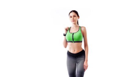 Genç ince kadın sporcu bir sportif yeşil kısa top ve poz spor salonu tozluk ve güleryüzlü bir beyaz izole arka planda Studio kapatın. Güzel bir sporcumuz portresi