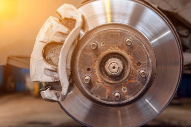 Bir araba tamir dükkanı asansörde üzerinde yükseltilmiş bir araba ağır yıpranmış arka davul frenler Close-up