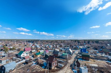 Ormanda eski bir tesiste köyünün havadan drone görünümü, arka planda bir gökyüzü. 