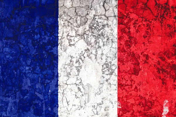 National flag of France on the background of the old wall covered with peeling paint. Concept of country, nation and patriotism symbol