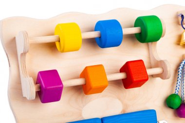 Ahşap meşgul tahta üzerinde çok renkli bulmacalar ile bir labirent yakın çekim- çocuklar için eğitim oyuncak, beyaz izole arka plan üzerinde bebekler. Çocukları eğlendiren ve dinlenen ebeveynler için bir oyuncak