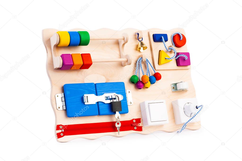 Wooden eco-friendly busy board - educational toy for children, babies on a white isolated background, consisting of a sorter, a zipper for clothes,  switch, beads, a labyrinth, a lock with a key, roller, bell, rosette.