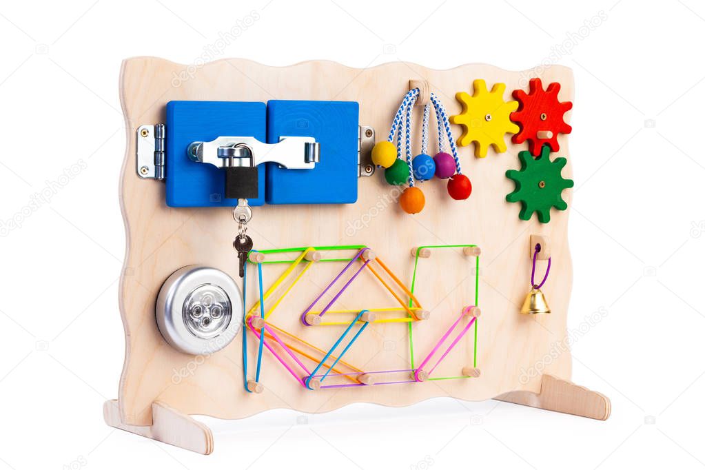 Wooden eco-friendly busy board-educational toy for children, babies on a white isolated background, consisting of a flashlight, beads, a maze, a lock with a key, roller, bell, gears.