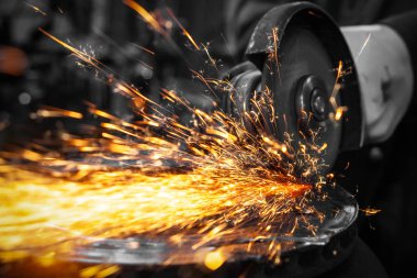 Bir oto tamir atölyesinde fren diskini kesmek için metal öğütücü kullanan bir araba tamircisinin yakın çekim, farklı yönlerde uçan parlak yanıp söner, bir oto tamir imal arka plan araçlarında