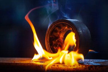 Oto tamirhanesinde benzinli brülör kullanılarak rulman otomotiv kısmının yakılması yakın çekim. Metal rulmanüzerinde yanan alev ateşi
