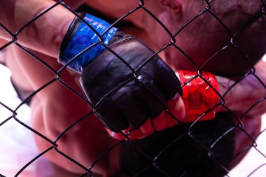 Yakın çekim bir rakip tutan ve sekizgen sahnenin arenada bir mücadele sırasında ona çarpıcı profesyonel güçlü Mma savaşçı. Ruh hali ve kuralsız mücadele kavramı. Teslim güreş 