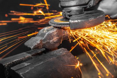 Yakın çekim parlak taraf anında açı kıyma makinesinden kıvılcım. Genç bir erkek kaynakçı bir beyaz eldiven çalışma açısı değirmeni garajda ile metal ürün biler