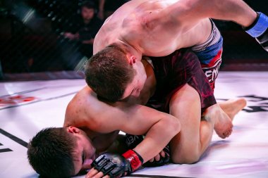 Novosibirsk, Rusya - 19 Nisan 2019: Salon of fam. Boxers dövüşçüleri, koyu renkli arka plandaki sirkte sekizgen halkada kuralsız dövüşlerde yerde güreştiler. Mma sürümüne göre kuralsız dövüşler