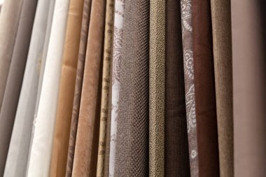 Dikiş perdeleri, yatak takımları ve giysiler için pamuk, polyester, goblen ve farklı renk ve baskılardan yapılmış kumaş parçalarının yakın çekim sıraları