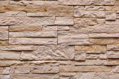 Bloklarla yapılan kahverengi taş duvarın arka planı. Arduvaz duvar dokusu ve arka plan deseni 