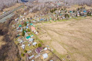 Sıcak, güneşli bir yaz gününde evler, yeşil bir orman ve büyük bir alan ile küçük bir köye bir quadrocopter Fotoğraf
