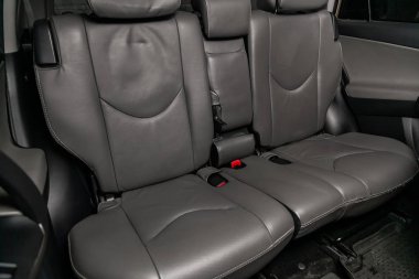  Otomobilin siyah ve kahverengi iç yakın çekim: deri arka koltuklar ve emniyet kemerleri . 