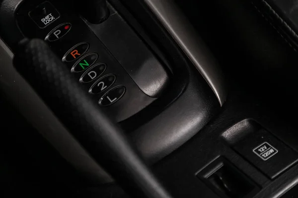 Close-up of the car  black interior:  dashboard, adjustment of the blower, air conditioner, accelerator handle and other buttons.