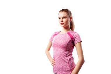 Sportif pembe üst poz ve ciddi stüdyoda beyaz izole arka plan bakarak genç bir ince kadın atlet. Güzel bir spor kadının portresi