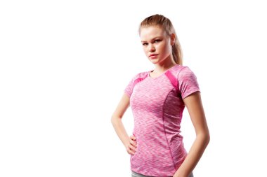 Sportif pembe üst poz ve ciddi stüdyoda beyaz izole arka plan bakarak genç bir ince kadın atlet. Güzel bir spor kadının portresi