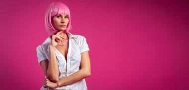 Neşeli yaz ruh hali kavramı, rahatlama ve güzellik. Kısa çekici kot pembe peruk güzel bir kadının yakın çekim, beyaz gömlek pembe bir arka plan üzerinde poz