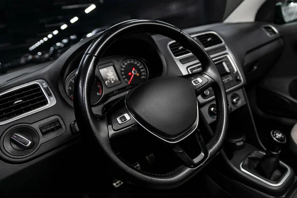 Interior view of car with black salon. Modern luxury prestige car interior:, dashboard, speedometer, tachometer  with white backlight  steering wheel  with car controller system function.