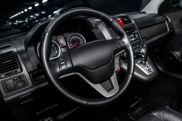 Interior view of car with black salon. Modern luxury prestige car interior:, dashboard, speedometer, tachometer  with white backlight  steering wheel  with car controller system function
