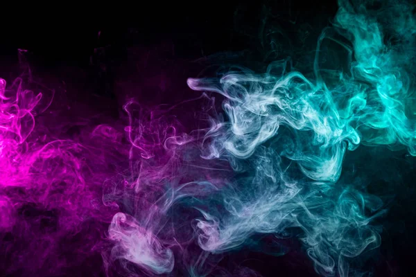 Pink and blue cloud of smoke of  black isolated background. Background from the smoke of vap