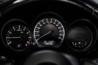 Siyah salonlu arabanın iç görünümü. Modern lüks prestij araba iç: speedometer, gösterge paneli ve beyaz arka ışık ve diğer düğmeleri ile takometre. 
