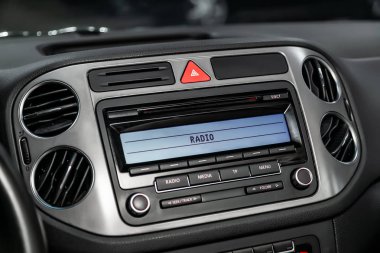Sıcaklık, radyo, saat ve diğer bilgilerle gösterge panelinin yakın çekim. Siyah salonlu arabanın iç görünümü.