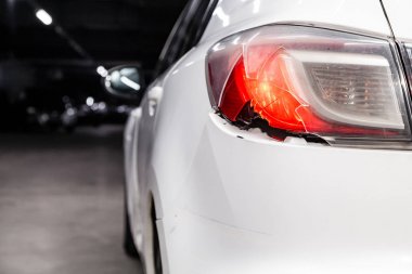 Spor ve modern tasarımı olan beyaz bir sedan yakın plan far parlıyor. Pahalı araba kavramı. Farlara, tamponlara ve araba tekerleklerine yakın çekim