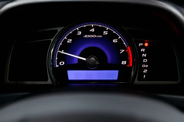 Interior view of car with black salon. Modern luxury prestige car interior: speedometer, dashboard and tachometer  with white backlight and other buttons. Soft focus