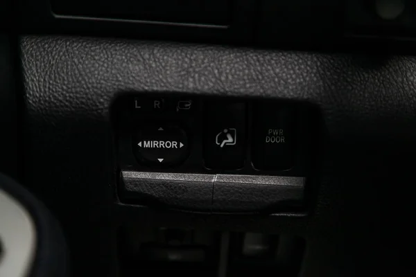 Close-up on the mirror side switch control buttons,  automatic adjust level dashboard. modern car interior: parts, buttons, knob