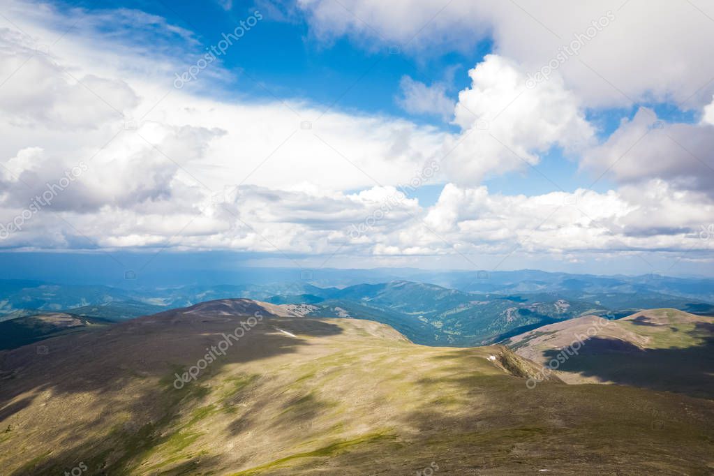 Amazing view on green mountains from a viewpoint. Panorama of the mountains  in Altai on a summer clear day. A landscape view of beautiful fresh green field   and  Altai mountain background.  