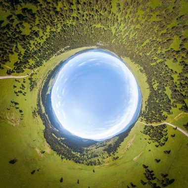 Helikopter drone vurdu. Yeşil bir ormanın yukarısındaki bir manzara ve sıcak, güneşli bir yaz gününde büyük bir alan. Yukarıdan çekilen panoramik şehir 360