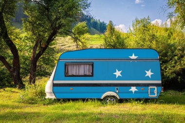 Bir araba römork, bir motor ev, Micronesia Federal Devletleri ulusal bayrağı boyalı bir dağlık park halinde duruyor. Ülkeler arasında karayolu taşımacılığı, ticareti, ihracatı ve ithalatı kavramı. Arabayla seyahat