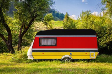 Bir araba römork, bir motor ev, Almanya ulusal bayrağı boyalı bir dağlık park halinde duruyor. Ülkeler arasında karayolu taşımacılığı, ticareti, ihracatı ve ithalatı kavramı. Arabayla seyahat