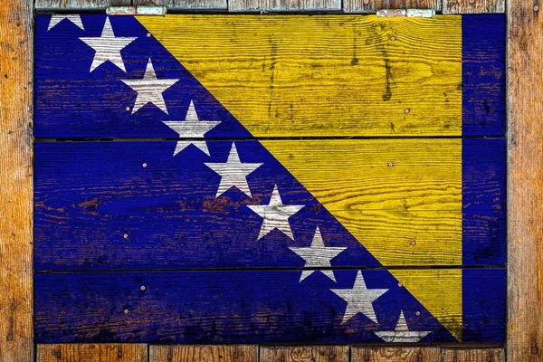 木製の壁の背景にボスニア ヘルツェゴビナの国旗 国の誇りと国のシンボルの概念 金属製の釘で木製のフェンスに描かれた旗 — ストック写真