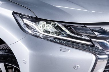 Novosibirsk, Rusya 30 Haziran 2019:gümüş Mitsubishi Pajero Sport, far yakın çekim, tampon, tekerlek. Novosibirsk bir otoparkta modern bir araba Fotoğraf