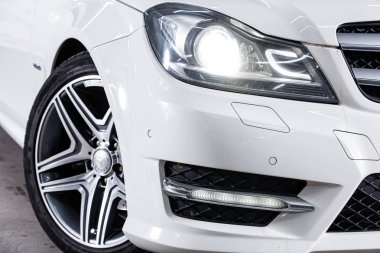 Novosibirsk, Rusya Temmuz 12, 2019: beyaz Mercedes-Benz c-class, far yakın çekim, tampon, tekerlek. Novosibirsk bir otoparkta modern bir araba Fotoğraf