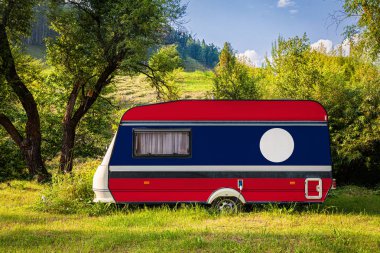 Bir araba römork, bir motor ev, Laos ulusal bayrağı boyalı bir dağlık park halinde duruyor. Ülkeler arasında karayolu taşımacılığı, ticareti, ihracatı ve ithalatı kavramı. Arabayla seyahat