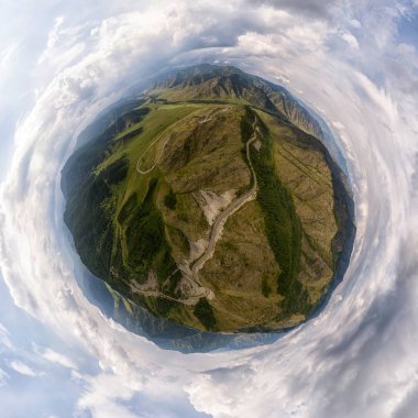 Helikopter drone'u vuruldu. Bir dağ, yeşil alan, yol, küçük köy ve orman hava fotoğrafçılığı. Panoramik şehir 360 yukarıdan çekim