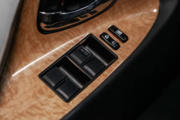 close-up of the side door buttons: window adjustment buttons, door lock. modern car interior: parts, buttons, knob