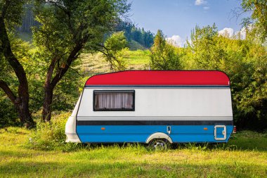 Bir araba römork, bir motor ev, Lüksemburg ulusal bayrağı boyalı bir dağlık park halinde duruyor. Ülkeler arasında karayolu taşımacılığı, ticareti, ihracatı ve ithalatı kavramı. Arabayla seyahat