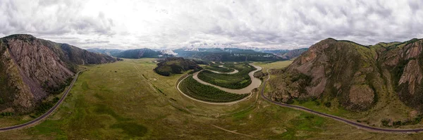 Güneşli bir günde yüksek dağlar, otoyol, iğne yapraklı orman çarpıcı manzara. Bir quadrocopter ile dağları fotoğraflama