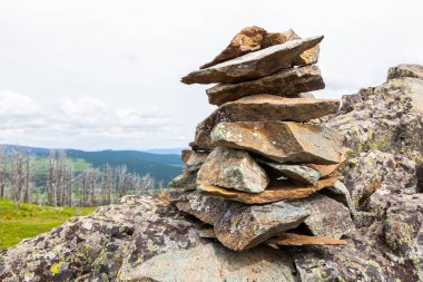 Bir uçurumdan düşen taşların yakın çekim, bir piramit ten oluşan dağlar ve ormanların arka planında duruyor. Gri taşın dokusu, arka plan.